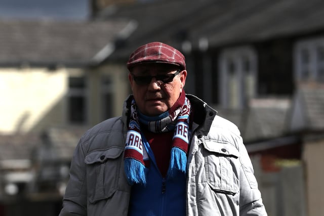 BURNLEY, ENGLAND - APRIL 02: A Burnley fan arrives at the stadium prior to the Premier League match between Burnley and Manchester City at Turf Moor on April 02, 2022 in Burnley, England. (Photo by Jan Kruger/Getty Images)