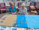 Two of the residents at Manor House, Chatburn, put the finishing touches to their summer scene art work which has gone on display