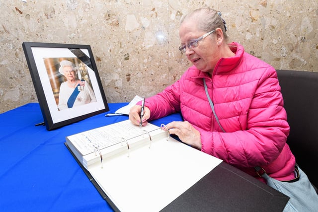 Member of the public Helene Stephens signs the book of condolence for The Queen at Wyre Civic Centre. Photo: Kelvin Stuttard