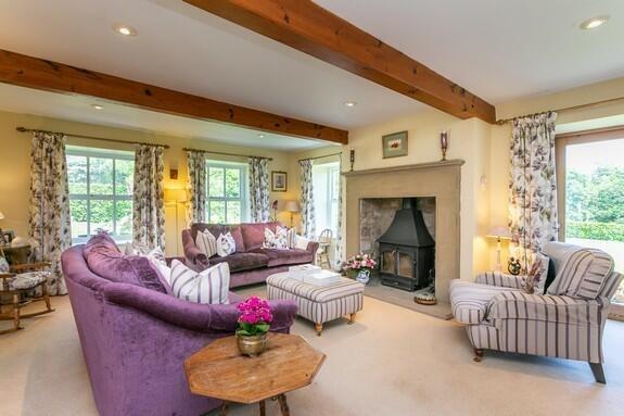 Sitting room with dressed stone Inglenook style fireplace with stone back and hearth housing 'Clear view' stove.