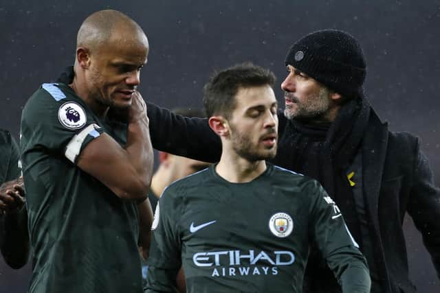 Manchester City's Spanish manager Pep Guardiola (R) gestures to Manchester City's Belgian defender Vincent Kompany (L) on the pitch after the English Premier League football match between Arsenal and Manchester City at the Emirates Stadium in London on March 1, 2018. 
Manchester City won the game 3-0.  / AFP PHOTO / IKIMAGES / Ian KINGTON