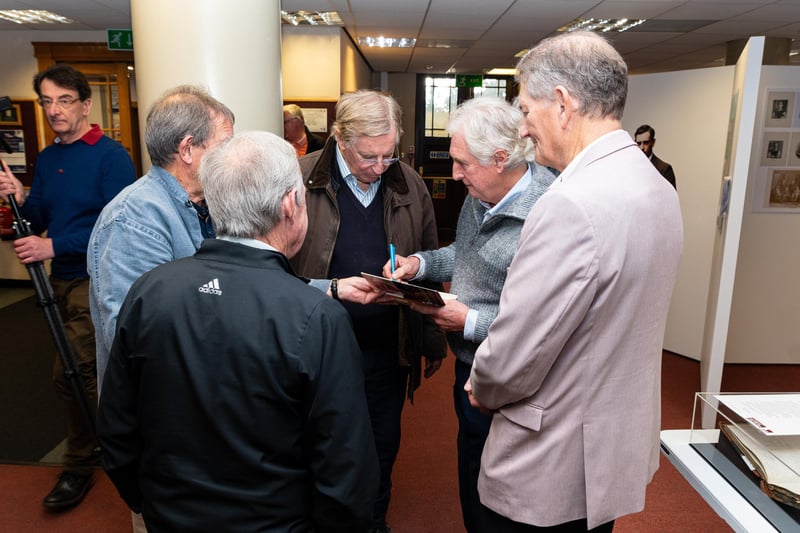 Colin Waldron, Paul Fletcher, Martin Dobson and Brian Flynn sign a book at the launch of the Clarets Resource Learning project at Burnley Central Library.