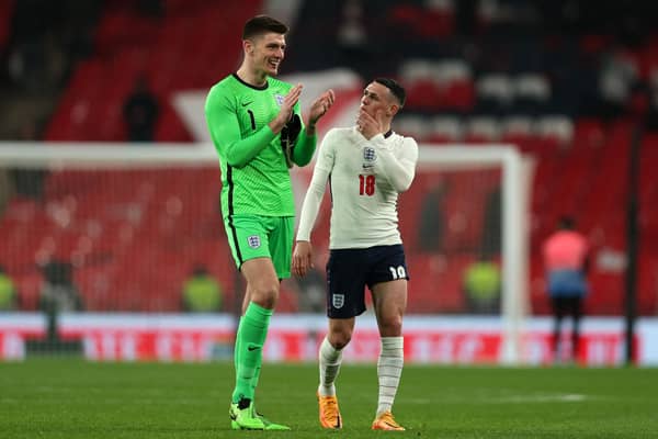 England's goalkeeper Nick Pope (L) and Englands's midfielder Phil Foden chat on the pitch after the international friendly football match between England and Ivory Coast at Wembley stadium in north London on March 29, 2022.