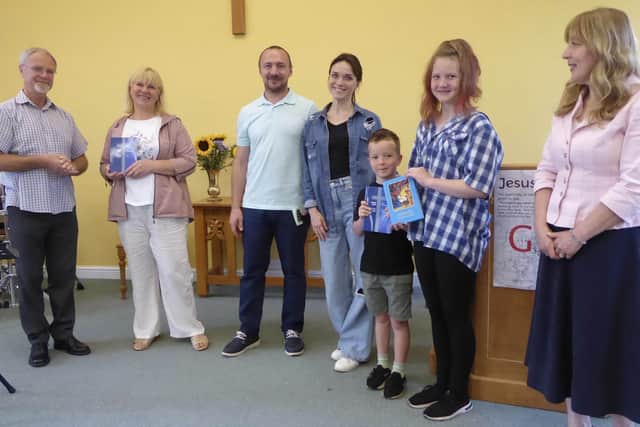 Bible gifts to Ukraine family at Mount Zion Church, Cliviger. From left: Martin Ashby-Smith, Nadiia, Oleksandr, Kateryna, Bohdan, Liz and Nadya Barnfather.