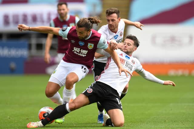 Burnley's English striker Jay Rodriguez (L) is tackled Sheffield United's English-born Northern Irish midfielder Oliver Norwood (R) during the English Premier League football match between Burnley and Sheffield United at Turf Moor in Burnley, north west England on July 5, 2020.