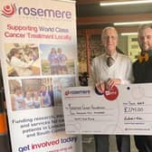 Richard Eden hands over a cheque for £2,245 , the amount his table top sale raised this year for Rosemere Cancer Foundation in memory of his partner James, to The Workshop cafe owner Bailey Routh.
