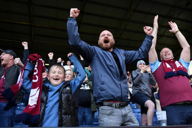 BURNLEY, ENGLAND - APRIL 24: Burnley fans celebrate after their sides victory during the Premier League match between Burnley and Wolverhampton Wanderers at Turf Moor on April 24, 2022 in Burnley, England. (Photo by Gareth Copley/Getty Images)
