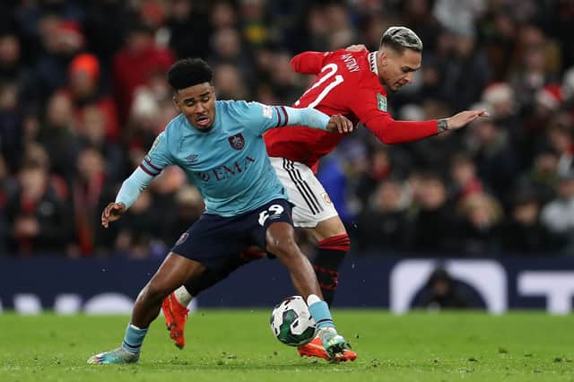 MANCHESTER, ENGLAND - DECEMBER 21: Ian Maatsen of Burnley is challenged by Antony of Manchester United during the Carabao Cup Fourth Round match between Manchester United and Burnley at Old Trafford on December 21, 2022 in Manchester, England. (Photo by Lewis Storey/Getty Images)