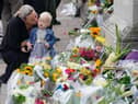 A woman kisses a small child as they look at the flowers laid outside Buckingham Palace, London, following the death of Queen Elizabeth II on Thursday. Picture date: Friday September 9, 2022.