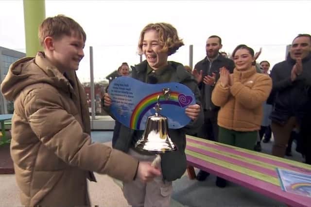 Hughie Higginson rings the 'end of treatment' bell at the Royal Manchester Children's Hospital watched by his best friend Freddie Xaxi, family, friends and well wishers