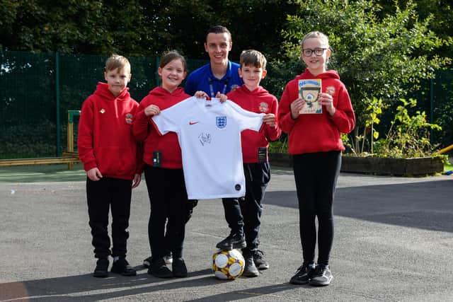 The winners: Pictured left to right are Luke Gowers, Hattie Trafford-Jones, Louis O'Hara-Lythgoe, Sophie Bend and teacher Jonathan Wood with the England shirt signed by Euro 2022 winner Millie Bright which was their prize after winning a national literacy competition.