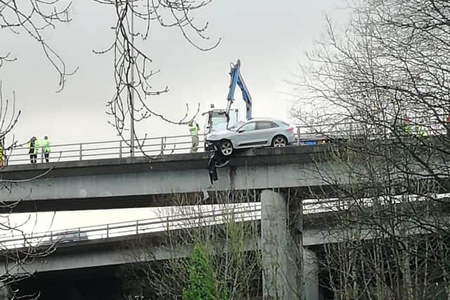 Pictures from the scene show a white car was left hanging off the carriageway