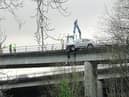 Pictures from the scene show a white car was left hanging off the carriageway