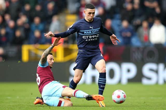 BURNLEY, ENGLAND - APRIL 02: Phil Foden of Manchester City is tackled by Josh Brownhill of Burnley during the Premier League match between Burnley and Manchester City at Turf Moor on April 02, 2022 in Burnley, England. (Photo by Alex Livesey/Getty Images)