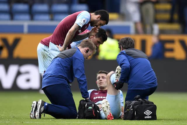 Burnley's English defender James Tarkowski is treated by medical staff during the English Premier League football match between Burnley and Aston Villa at Turf Moor in Burnley, north west England on May 7, 2022.