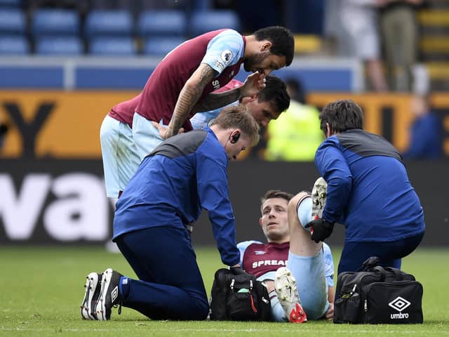 Burnley's English defender James Tarkowski is treated by medical staff during the English Premier League football match between Burnley and Aston Villa at Turf Moor in Burnley, north west England on May 7, 2022.