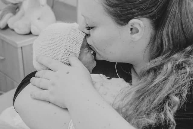A touching image of Maddie with her newborn son Thomas Christopher who died in January not long after he was born