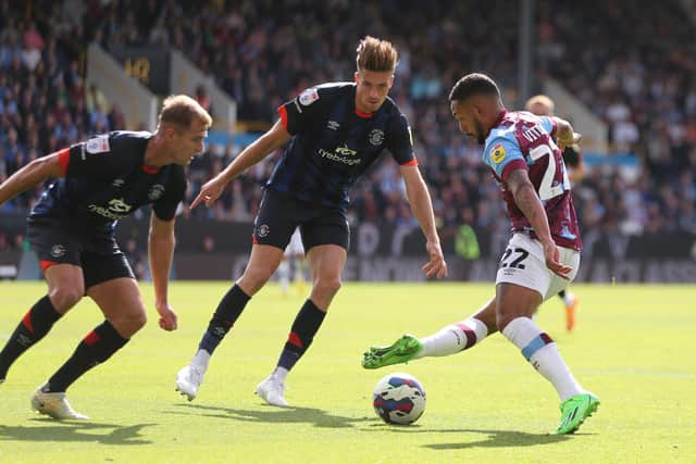 BURNLEY, ENGLAND - AUGUST 06: Vitinho of Burnley FC tries to get passed Reece Burke and James Bree of Luton Town during the Sky Bet Championship match between Burnley and Luton Town at Turf Moor on August 06, 2022 in Burnley, England. (Photo by Ashley Allen/Getty Images)