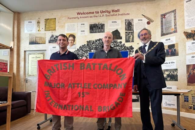 Lewis Ashworth, Gary Webb and Coun Brian Newman with an International Brigade flag