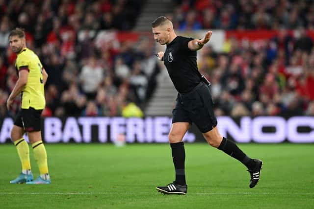 NOTTINGHAM, ENGLAND - SEPTEMBER 18: Referee Robert Jones disallows the goal scored by Lyle Foster of Burnley (not pictured) after a VAR check for handball during the Premier League match between Nottingham Forest and Burnley FC at City Ground on September 18, 2023 in Nottingham, England. (Photo by Shaun Botterill/Getty Images)
