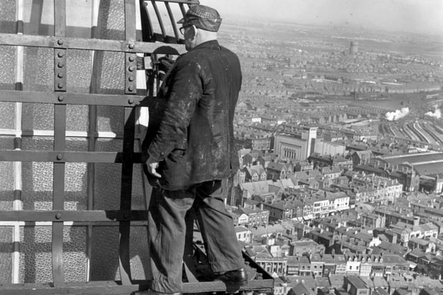 There's not  a hard hat in sight for this brave chap painting away at the top - 1953
