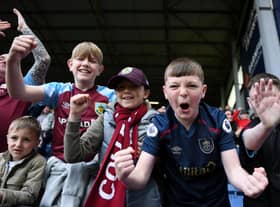 BURNLEY, ENGLAND - APRIL 24: Young Burnley fans celebrate their side's win after the final whistle of the Premier League match between Burnley and Wolverhampton Wanderers at Turf Moor on April 24, 2022 in Burnley, England. (Photo by Gareth Copley/Getty Images)