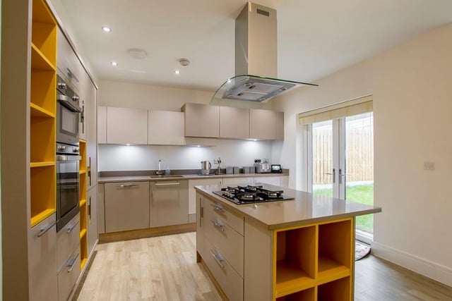 The open plan living kitchen features modern fixtures and fittings, as well as a useful central island.