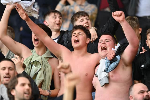 Jubilant Burnley fans celebrate after the English Premier League football match between Watford and Burnley at Vicarage Road Stadium in Watford, north-west of London, on April 30, 2022. - Burnley won the game 2-1.