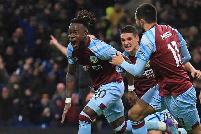 Burnley's Ivorian forward Maxwel Cornet (L) celebrates after scoring there third goal during the English Premier League football match between Burnley and Everton at Turf Moor in Burnley, north west England on April 6, 2022. - RESTRICTED TO EDITORIAL USE. No use with unauthorized audio, video, data, fixture lists, club/league logos or 'live' services. Online in-match use limited to 120 images. An additional 40 images may be used in extra time. No video emulation. Social media in-match use limited to 120 images. An additional 40 images may be used in extra time. No use in betting publications, games or single club/league/player publications. (Photo by Lindsey Parnaby / AFP) / RESTRICTED TO EDITORIAL USE. No use with unauthorized audio, video, data, fixture lists, club/league logos or 'live' services. Online in-match use limited to 120 images. An additional 40 images may be used in extra time. No video emulation. Social media in-match use limited to 120 images. An additional 40 images may be used in extra time. No use in betting publications, games or single club/league/player publications. / RESTRICTED TO EDITORIAL USE. No use with unauthorized audio, video, data, fixture lists, club/league logos or 'live' services. Online in-match use limited to 120 images. An additional 40 images may be used in extra time. No video emulation. Social media in-match use limited to 120 images. An additional 40 images may be used in extra time. No use in betting publications, games or single club/league/player publications. (Photo by LINDSEY PARNABY/AFP via Getty Images)