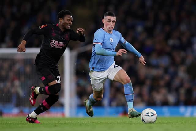 MANCHESTER, ENGLAND - MARCH 18: Phil Foden of Manchester City runs with the ball while under pressure from Nathan Tella of Burnley during the Emirates FA Cup Quarter Final match between Manchester City and Burnley at Etihad Stadium on March 18, 2023 in Manchester, England. (Photo by Clive Brunskill/Getty Images)