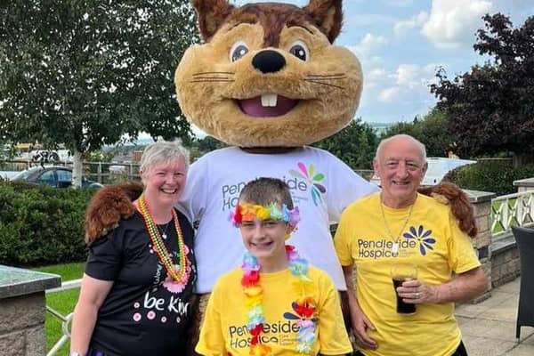 Alfie Hale at the end of his walk a mile a day challenge for Pendleside Hospice with his parents Jane and Gordon and hospice mascot Penny