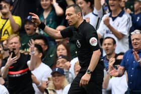 English referee Kevin Friend indicates a penalty to Spurs after consulting the pitch-side monitor for a handball after a VAR (Video Assistant Referee) review during the English Premier League football match between Tottenham Hotspur and Burnley at Tottenham Hotspur Stadium in London, on May 15, 2022. - - RESTRICTED TO EDITORIAL USE. No use with unauthorized audio, video, data, fixture lists, club/league logos or 'live' services. Online in-match use limited to 120 images. An additional 40 images may be used in extra time. No video emulation. Social media in-match use limited to 120 images. An additional 40 images may be used in extra time. No use in betting publications, games or single club/league/player publications. (Photo by Glyn KIRK / AFP) / RESTRICTED TO EDITORIAL USE. No use with unauthorized audio, video, data, fixture lists, club/league logos or 'live' services. Online in-match use limited to 120 images. An additional 40 images may be used in extra time. No video emulation. Social media in-match use limited to 120 images. An additional 40 images may be used in extra time. No use in betting publications, games or single club/league/player publications. / RESTRICTED TO EDITORIAL USE. No use with unauthorized audio, video, data, fixture lists, club/league logos or 'live' services. Online in-match use limited to 120 images. An additional 40 images may be used in extra time. No video emulation. Social media in-match use limited to 120 images. An additional 40 images may be used in extra time. No use in betting publications, games or single club/league/player publications. (Photo by GLYN KIRK/AFP via Getty Images)