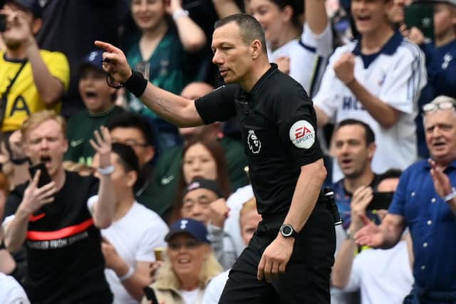 English referee Kevin Friend indicates a penalty to Spurs after consulting the pitch-side monitor for a handball after a VAR (Video Assistant Referee) review during the English Premier League football match between Tottenham Hotspur and Burnley at Tottenham Hotspur Stadium in London, on May 15, 2022. - - RESTRICTED TO EDITORIAL USE. No use with unauthorized audio, video, data, fixture lists, club/league logos or 'live' services. Online in-match use limited to 120 images. An additional 40 images may be used in extra time. No video emulation. Social media in-match use limited to 120 images. An additional 40 images may be used in extra time. No use in betting publications, games or single club/league/player publications. (Photo by Glyn KIRK / AFP) / RESTRICTED TO EDITORIAL USE. No use with unauthorized audio, video, data, fixture lists, club/league logos or 'live' services. Online in-match use limited to 120 images. An additional 40 images may be used in extra time. No video emulation. Social media in-match use limited to 120 images. An additional 40 images may be used in extra time. No use in betting publications, games or single club/league/player publications. / RESTRICTED TO EDITORIAL USE. No use with unauthorized audio, video, data, fixture lists, club/league logos or 'live' services. Online in-match use limited to 120 images. An additional 40 images may be used in extra time. No video emulation. Social media in-match use limited to 120 images. An additional 40 images may be used in extra time. No use in betting publications, games or single club/league/player publications. (Photo by GLYN KIRK/AFP via Getty Images)