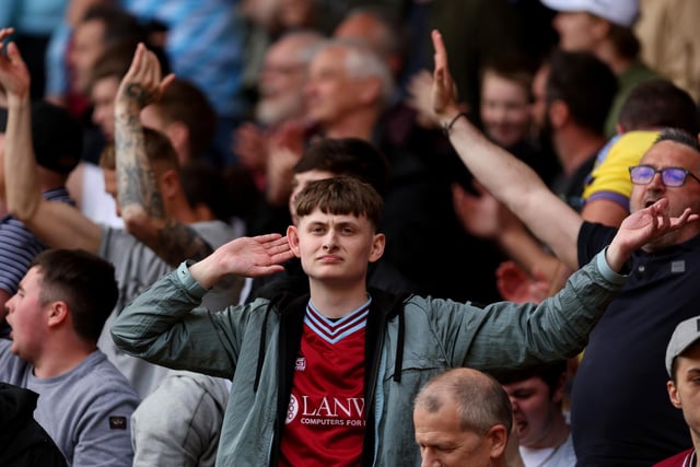 WATFORD, ENGLAND - APRIL 30: Burnley fans celebrate after their sides victory during the Premier League match between Watford and Burnley at Vicarage Road on April 30, 2022 in Watford, England. (Photo by Julian Finney/Getty Images)