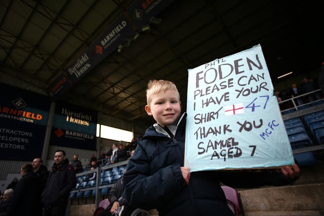 BURNLEY, ENGLAND - APRIL 02: A Manchester City fan displays a banner asking for the shirt of Phil Foden prior to the Premier League match between Burnley and Manchester City at Turf Moor on April 02, 2022 in Burnley, England. (Photo by Jan Kruger/Getty Images)