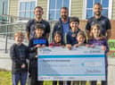Burnley FC players Josh Brownhill (left) and Jay Rodriguez (right) presenting the cheque to Ben Bottomley (middle) from Burnley FC in the Community at Whitehough Outdoor Centre. Also in the picture are children from St Mary's CE Primary School, Rawtenstall.