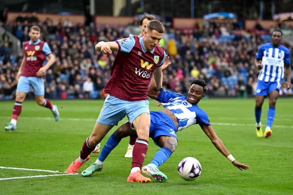 BURNLEY, ENGLAND - APRIL 13: Maxime Esteve of Burnley challenges Simon Adingra of Brighton & Hove Albion during the Premier League match between Burnley FC and Brighton & Hove Albion at Turf Moor on April 13, 2024 in Burnley, England. (Photo by Gareth Copley/Getty Images) (Photo by Gareth Copley/Getty Images)