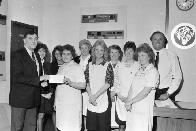 Mr Alan Bullas receives the cheque from Mrs Hanna watched by other workers and brother Charlie, right.
Workers at Lucas Electrical’s Eastern Avenue factory have presented another cheque to the Burnley and Pendle Hospice Appeal.
