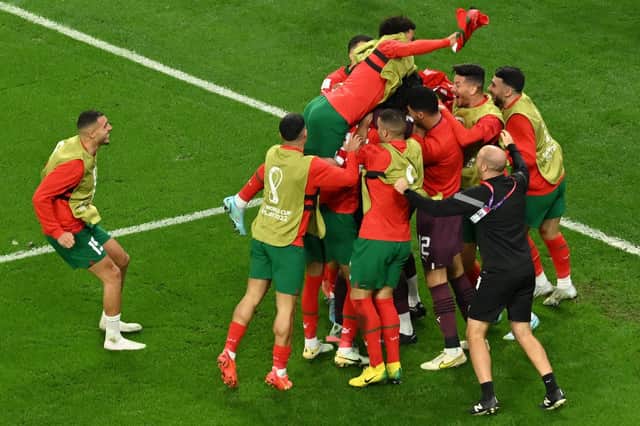 Morocco's players celebrate at the end of the Qatar 2022 World Cup round of 16 football match between Morocco and Spain at the Education City Stadium in Al-Rayyan, west of Doha on December 6, 2022. (Photo by Glyn KIRK / AFP) (Photo by GLYN KIRK/AFP via Getty Images)