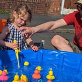 Imogen Salisbury plays Hook a Duck during a Clitheroe street party to celebrate the king's coronation.