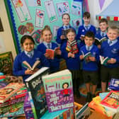 Pupils at St James CE School in Clitheroe with books donated to them by Miller Homes.