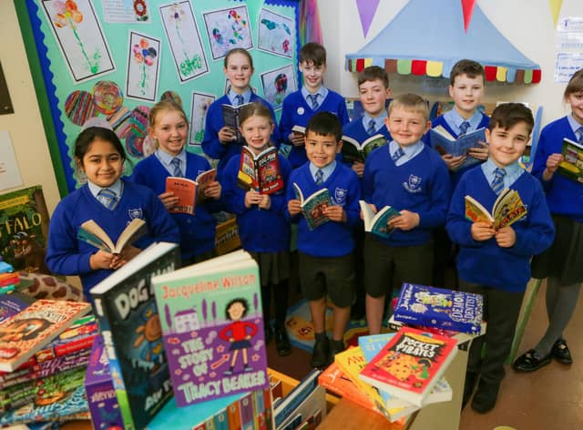 Pupils at St James CE School in Clitheroe with books donated to them by Miller Homes.