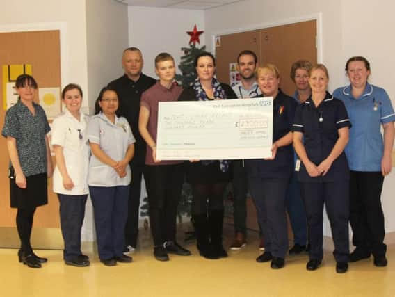 Sarah Bernasconi and Mark Parsons hand over a cheque for 2,300 to Burnley General Hospital for the quiet room.