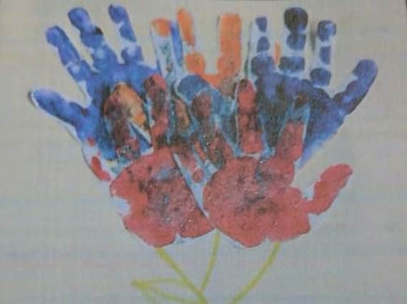 The babies used hand paints to make the Queen a birthday card.