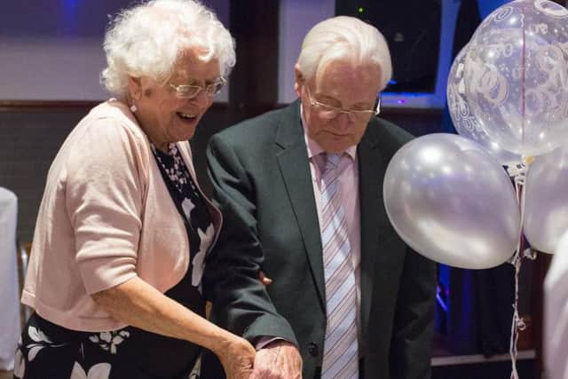 Thomas and Cecilia Edmondson cutting their cake at a party for their 70th wedding anniversary. (s)