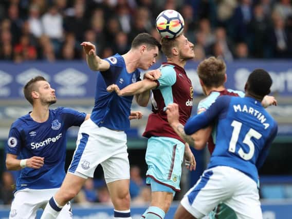 Michael Keane challenges Chris Wood for the ball