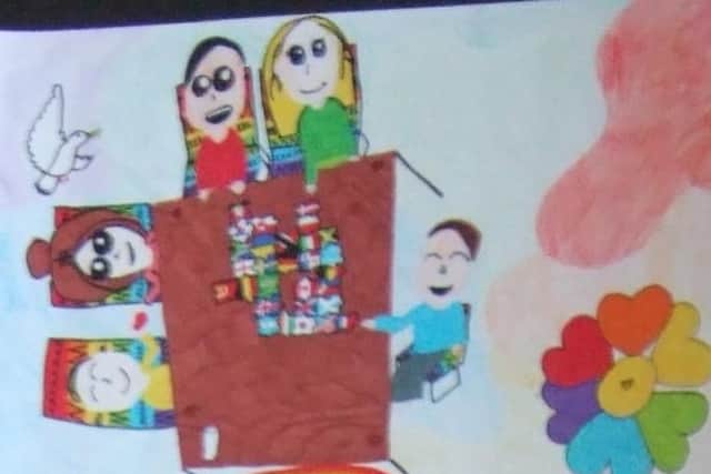 Alessandra's prize winning posters shows children from different backgrounds doing a jigsaw together with each piece representing a flag of the world.