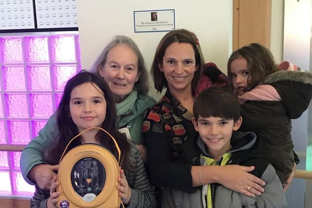 Josh's family - from left to right, mum Susan, widow Chloe holding daughter Naomi, daughter Amelie holding the new defibrillator for Clitheroe's The Grand, and son Benjy.