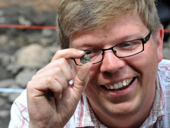 Dr Jim Morris with a coin found during  the 2017 dig