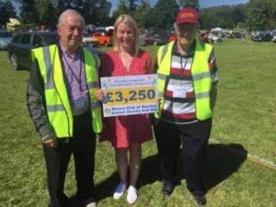 Burnley Rotary President Neil Beecham and Donald George presenting the cheque to Pendleside Hospice trustee Nicola Alden